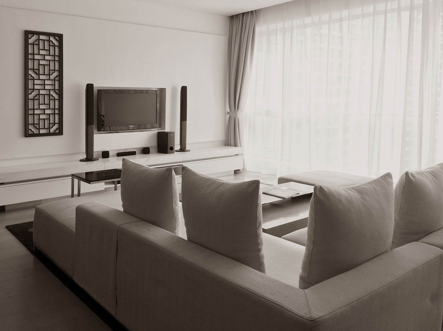 Sala de estar, com uma televisão e um sofá, no apartamento de Xangai antes de ser renovado.