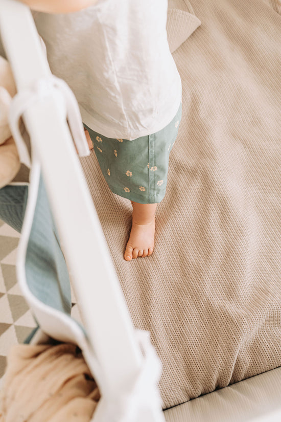 Detalhe do pé de uma criança na cama, no quarto dos gêmeos renovado.