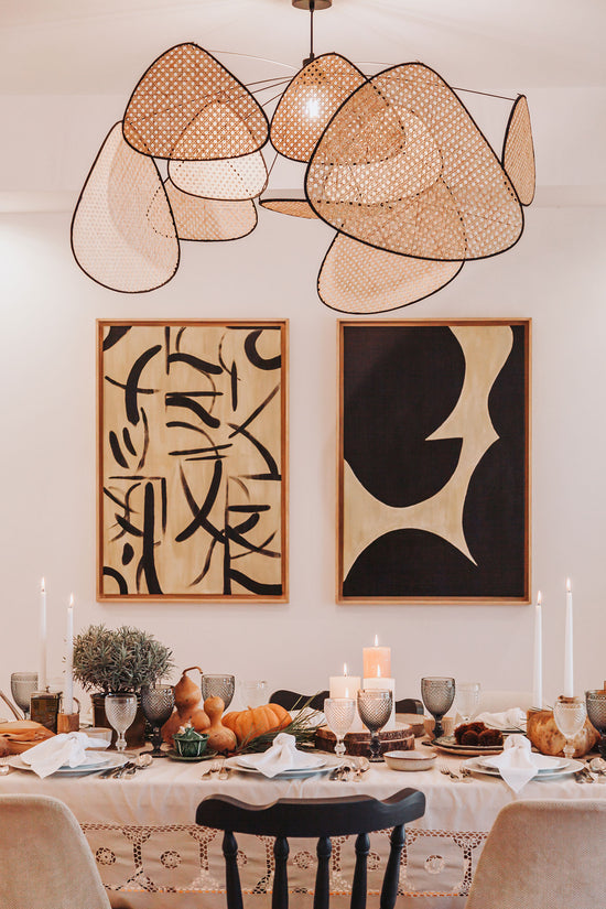Sala de jantar no apartamento de Alcochete, com dois quadros com formas orgânicas na parede de fundo.