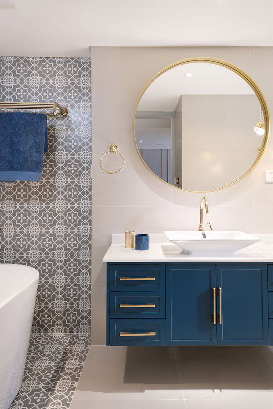 Detalhes do espelho e do móvel do lavatório em azul e dourado, no apartamento renovado em Telheiras.